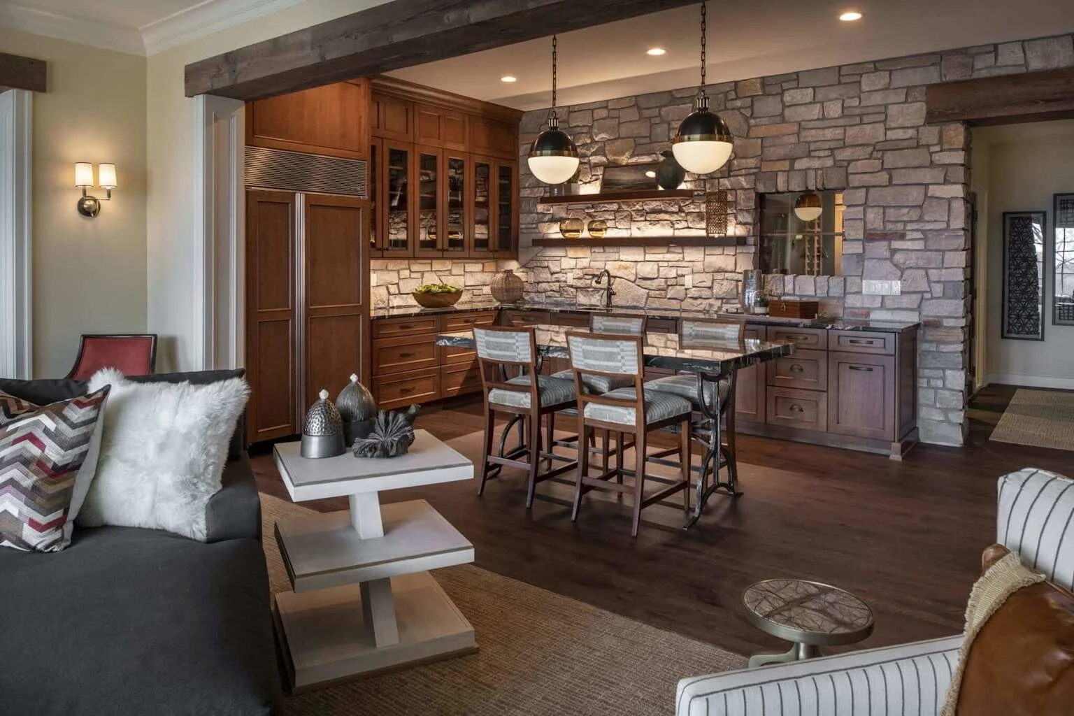 Custom basement entertainment room with wet bar, stone accent wall, and wood cabinetry built by RAM Builder Services