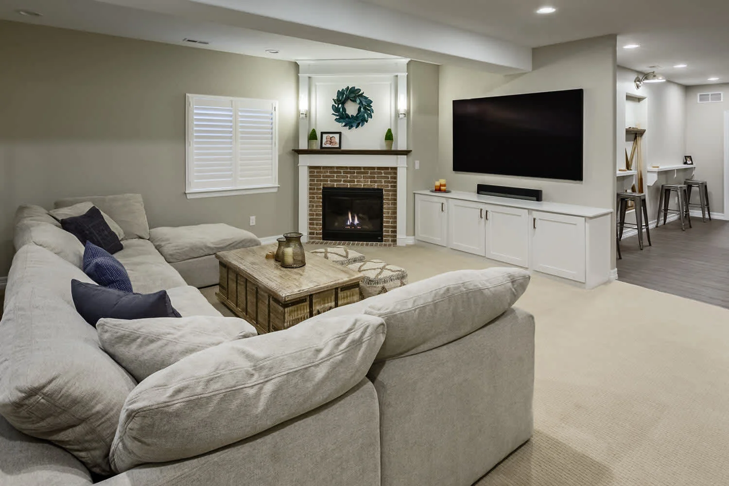 Spacious finished basement family room with L-shaped sectional, gas fireplace, TV, and built-in cabinetry